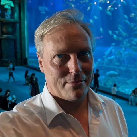 Bernard Duchenne in front of a giant aquarium window